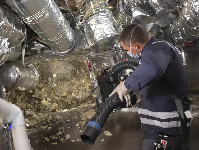 Holliston Air Duct Cleaning specialist operating negative pressure cleaning equipment for thorough duct maintenance in Holliston